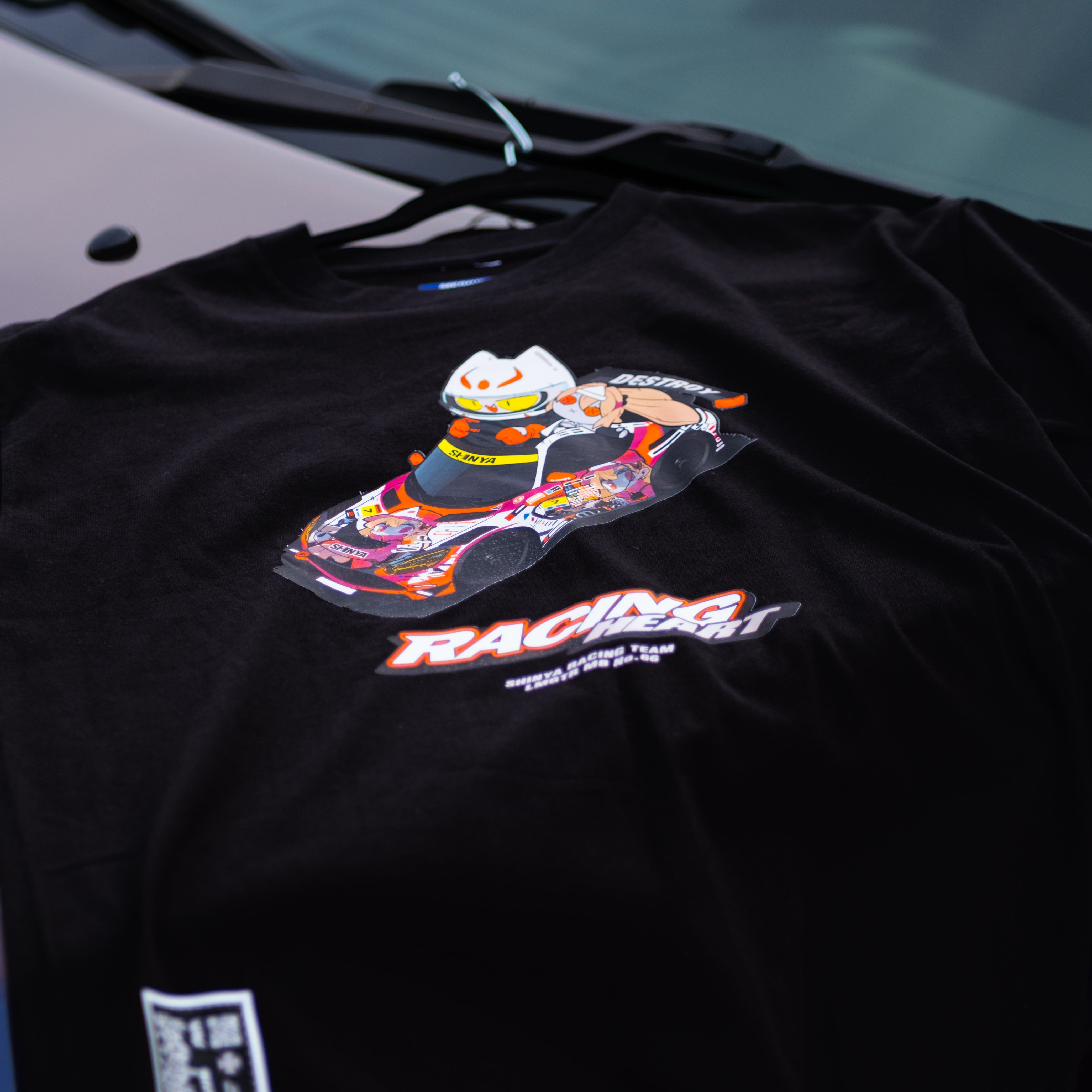Black t-shirt with colorful graphic design on a car seat